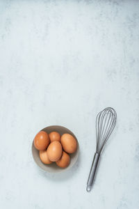 Some eggs and a beater on a cooktop