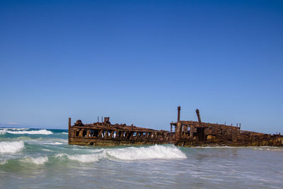 Photograph of the shipwreck of the ss maheno on fraser island with a cloudless sky in the background