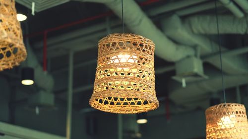 Low angle view of illuminated lighting equipment hanging at restaurant