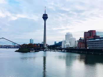 View of suspension bridge over river with city in background