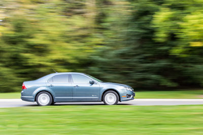 Modern car driving down country road