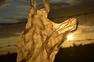 Close-up of plastic bag against sky during sunset