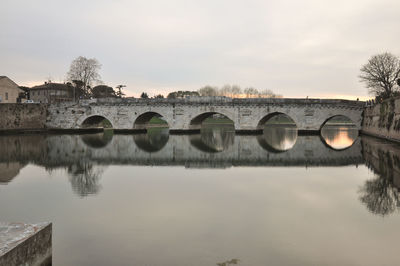 Arch bridge over river against sky