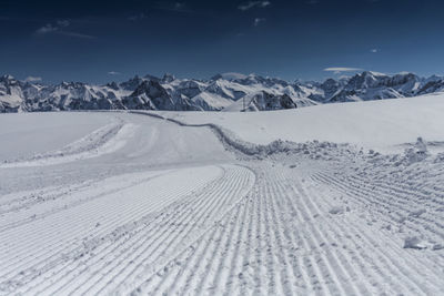 Tire tracks on snow covered landscape