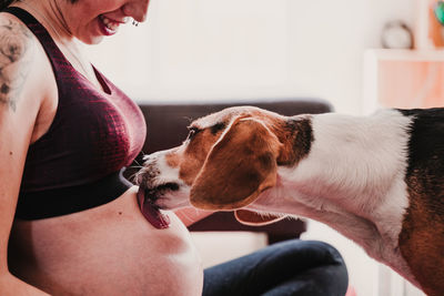 Pregnant woman with dog sitting at home