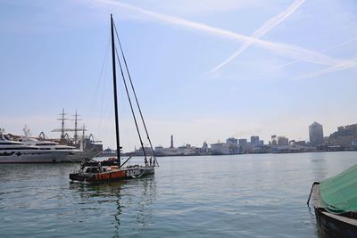 Sailboats moored in sea against sky