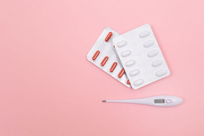 High angle view of colored pencils over pink background