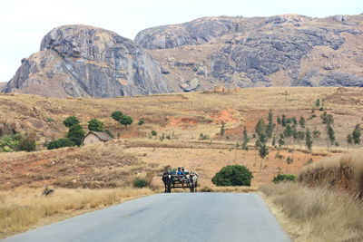 Rear view of person on road against mountain range