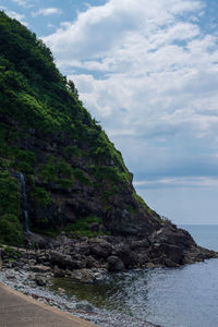 Rock formations by sea against sky