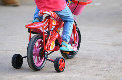 Low section of girl riding bicycle on road