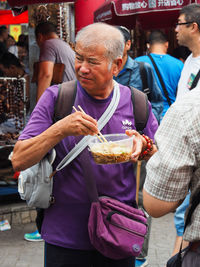 People holding food at market stall