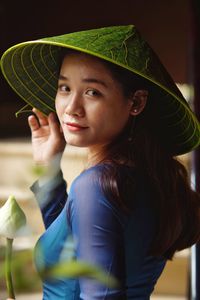 Portrait of young woman holding hat