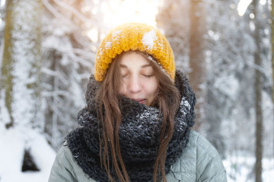 A beautiful young caucasian woman with closed eyes and a smile on her face relaxes and enjoys the