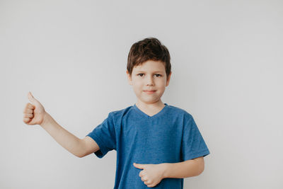 Portrait of boy standing against white background