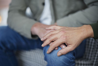 Female hand touching man's knee