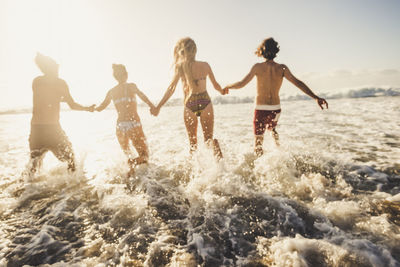 Group of people running on beach