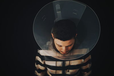 Man in glass against black background