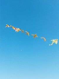 Low angle view of trees against clear blue sky