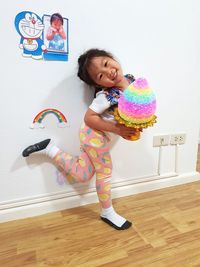 Full length of cute happy girl on floor at home