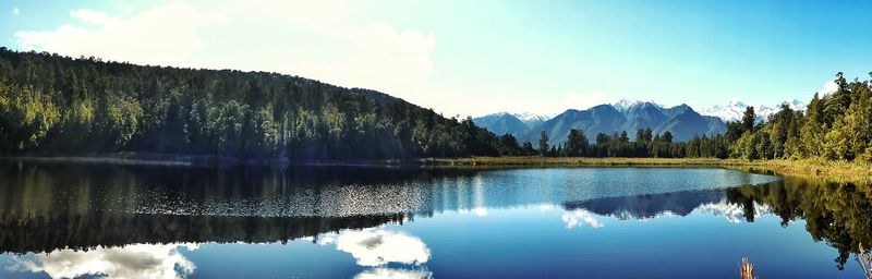 Panoramic view of lake and mountains against blue sky