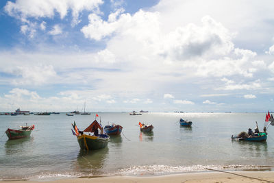 Boats moored on sea against sky