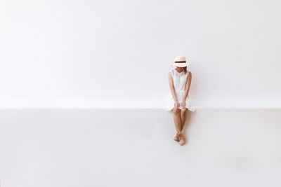 Close-up of woman against white wall