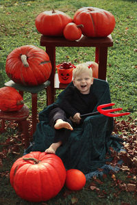 High angle view of boy with pumpkins on field