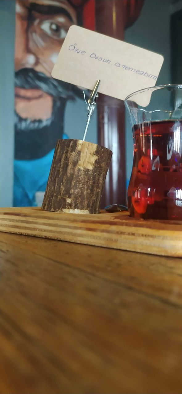 food and drink, wood, indoors, red, food, table, drink, selective focus, jar, container, refreshment, business, one person, glass, adult