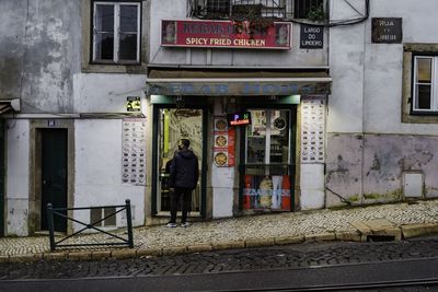 Man standing on sidewalk by building