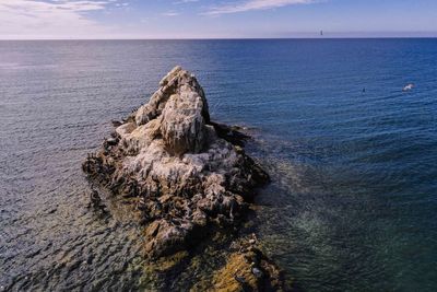 Rock formation on sea against sky
