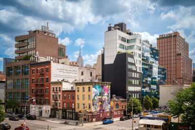 Buildings in city against cloudy sky