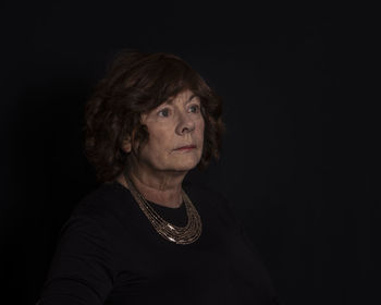 Senior woman against black background