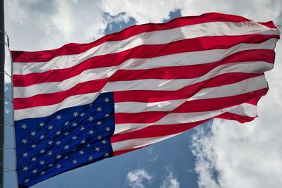 Low angle view of flag flags against sky