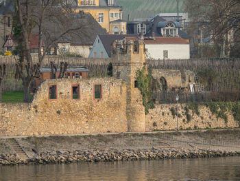 Old building by river in city