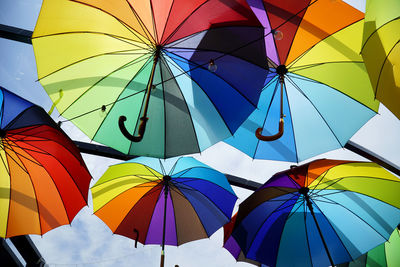 Low angle view of umbrellas hanging against sky