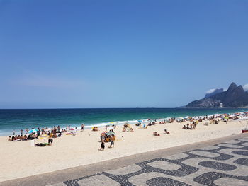 People at beach against blue sky