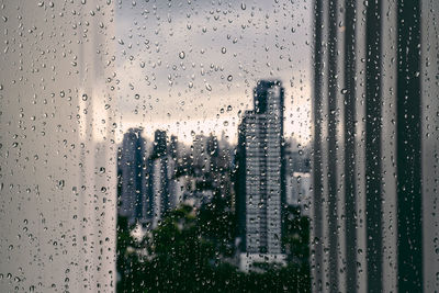 Raindrops on glass window in city
