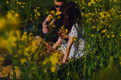 Young woman standing amidst yellow flowers