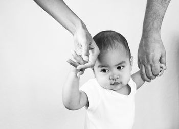Portrait of father holding baby against white background