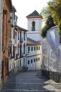 Houses by street against sky