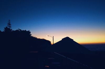 Silhouette trees against sky at sunset