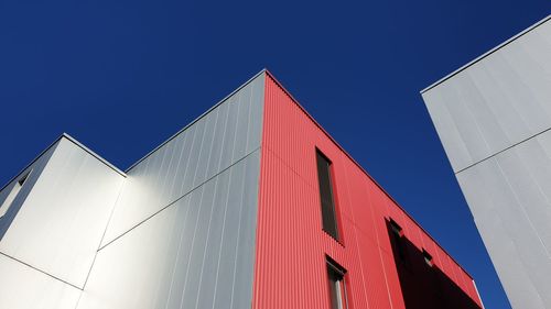 Low angle view of modern building against clear blue sky