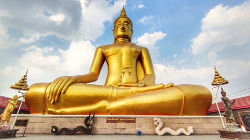 Low angle view of statue against temple building against sky