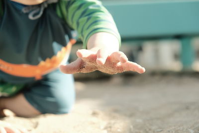 Portrait of boy playing with sand at beach