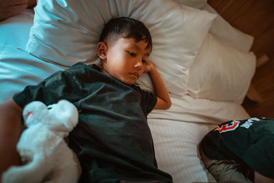 High angle view of boy sleeping on bed at home