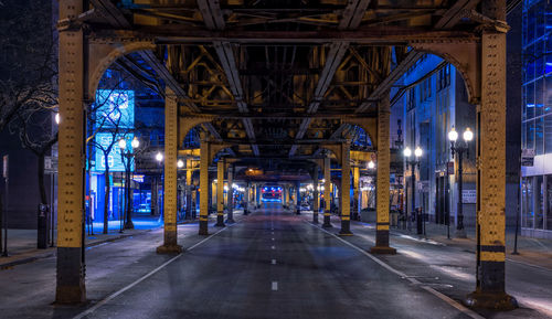 Underneath illuminated railway bridge in chicago at night