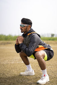 Full length of woman exercising on field