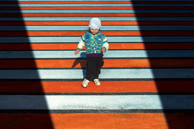 Full length of boy on red umbrella