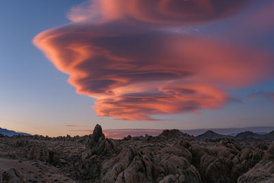 Looking up at the sky at sunset with a vibrant lenticular cloud overhead 