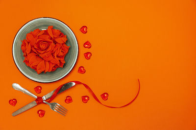 High angle view of red bell against orange background